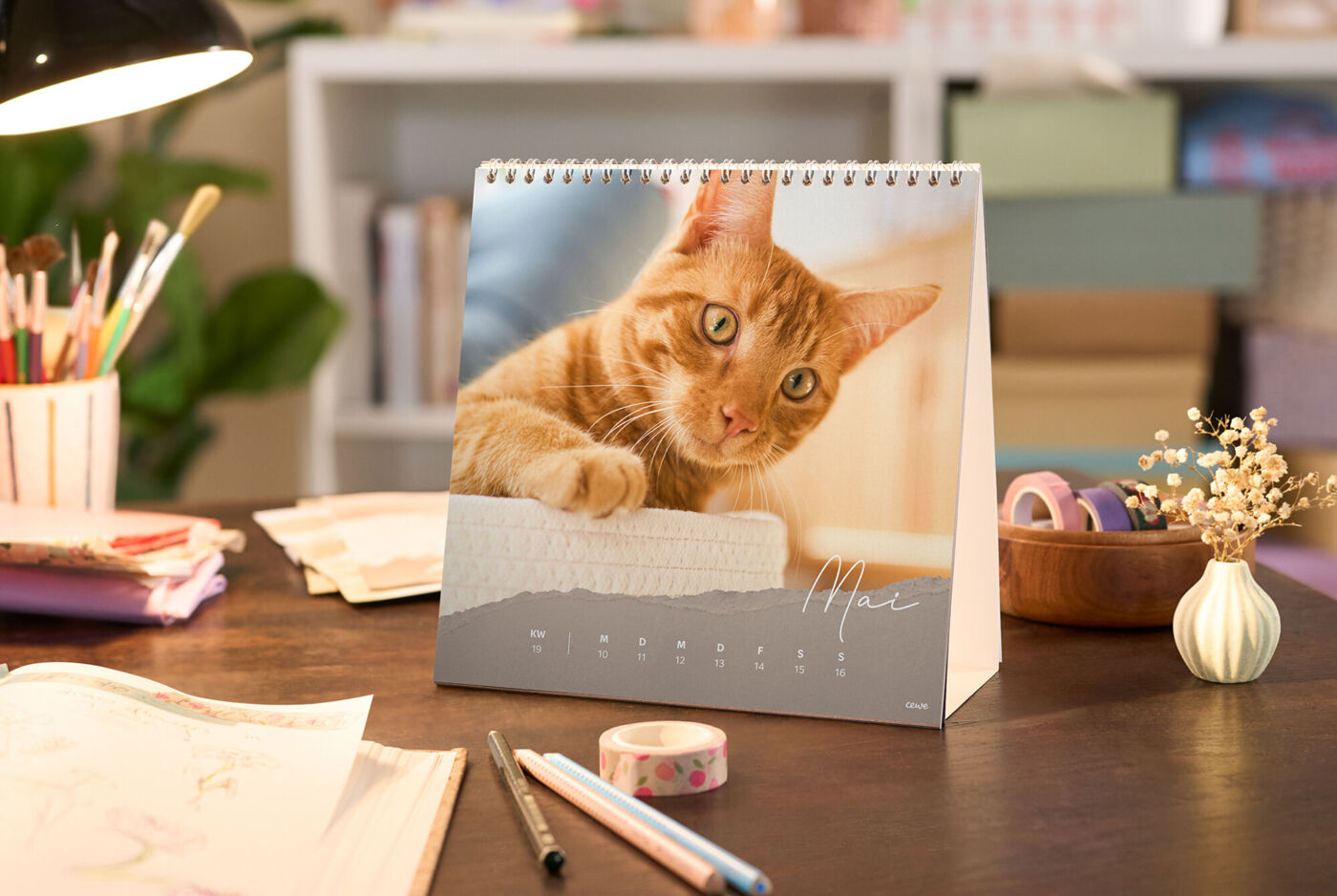 CEWE-Fotokalender auf Schreibtisch mit Foto einer orangefarbenen Katze, Monat Mai gut lesbar gestaltet